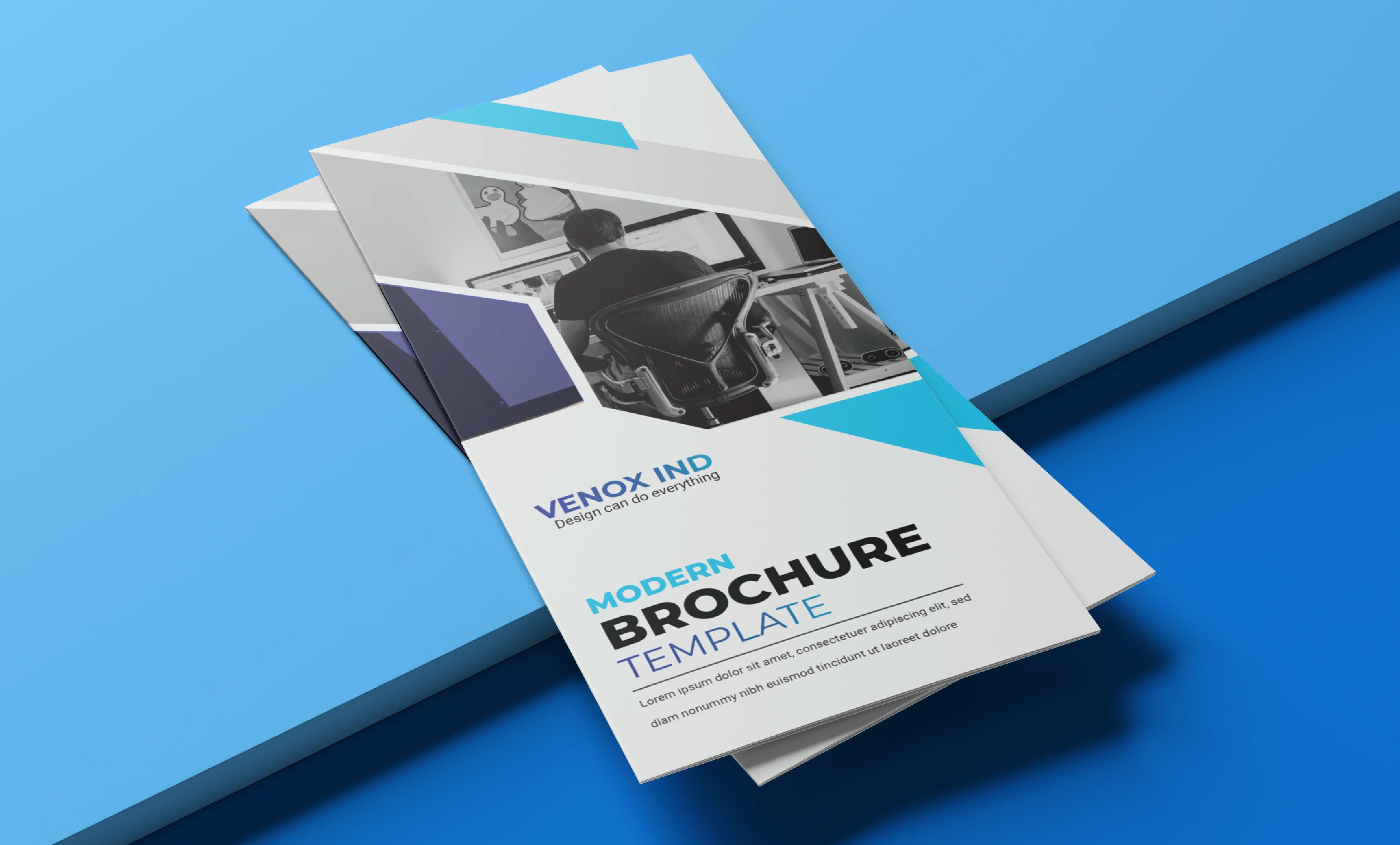 Modern trifold brochure for Venox Ind, its cover panel built from angular blue and teal shapes over a studio workspace photograph, designed by 360Kreations